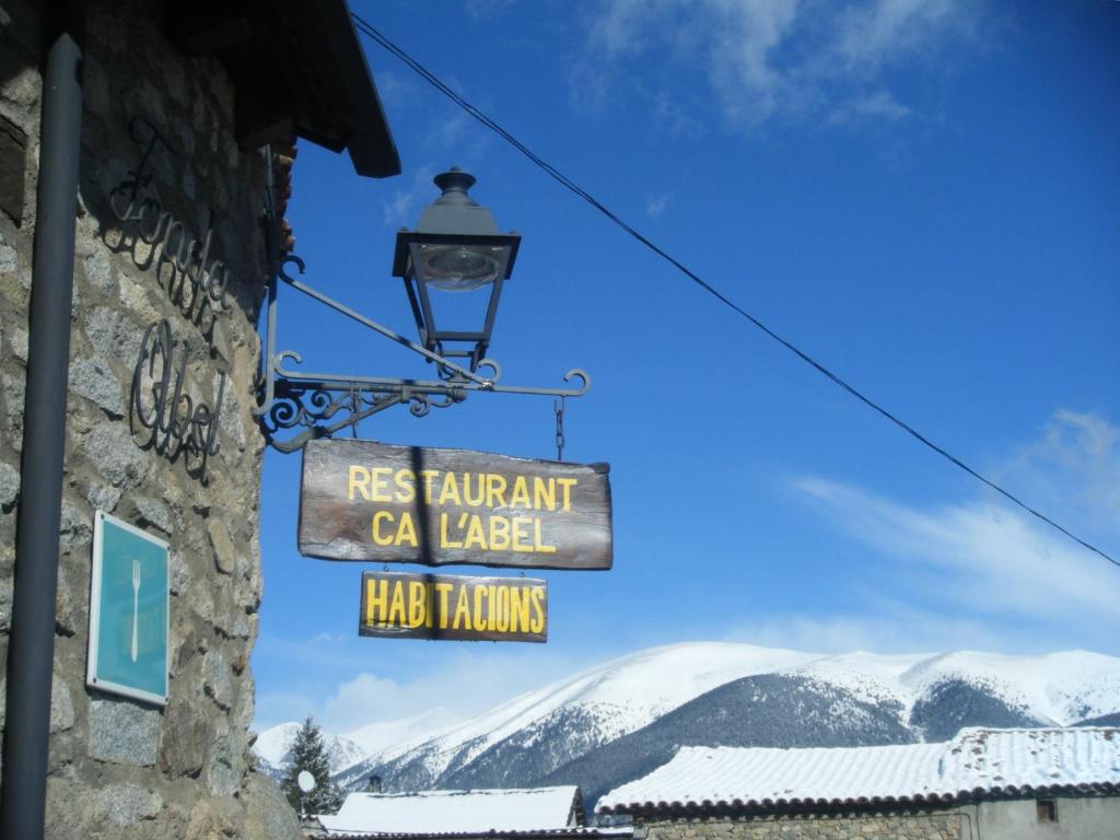 a sign on the side of a building with mountains at Fonda Ca l'Abel in Lles