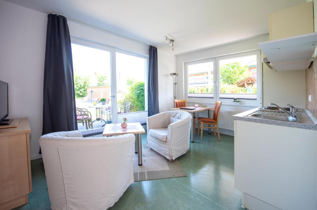 een keuken en een woonkamer met een tafel en stoelen bij De Kanalkieker Apartmenthaus Meier in Berkenthin