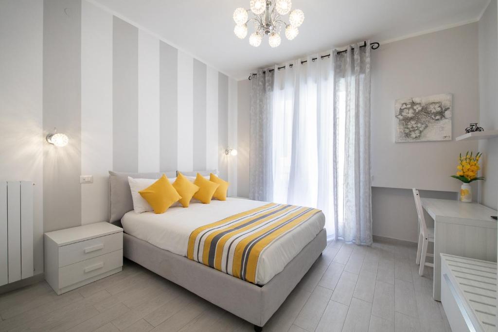 um quarto com uma cama com almofadas amarelas e uma secretária em Casa La Perla em Sorrento