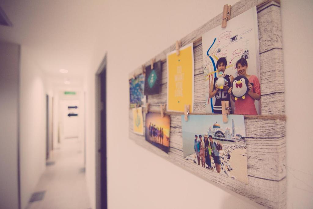 einen Flur mit einer Reihe von Bildern an einer Wand in der Unterkunft The Haven Inn in Malakka