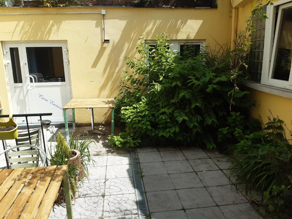 a garden outside a house with a bench and a bush at Casa ENRICO in Antwerp