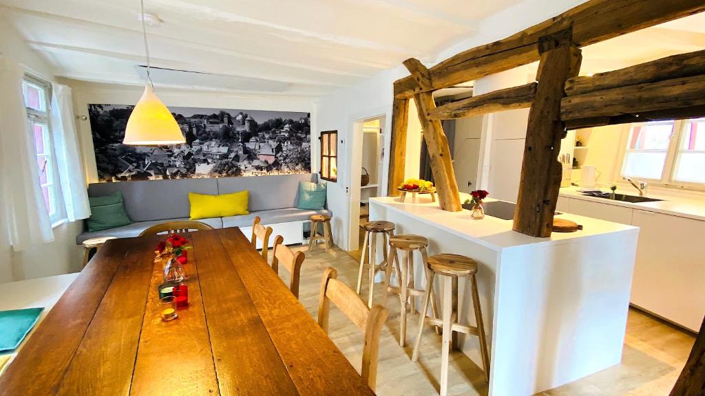 eine Küche und ein Wohnzimmer mit einem Holztisch und Stühlen in der Unterkunft Monschau-Auszeit: Historisch wohnen direkt am Bach in Monschau