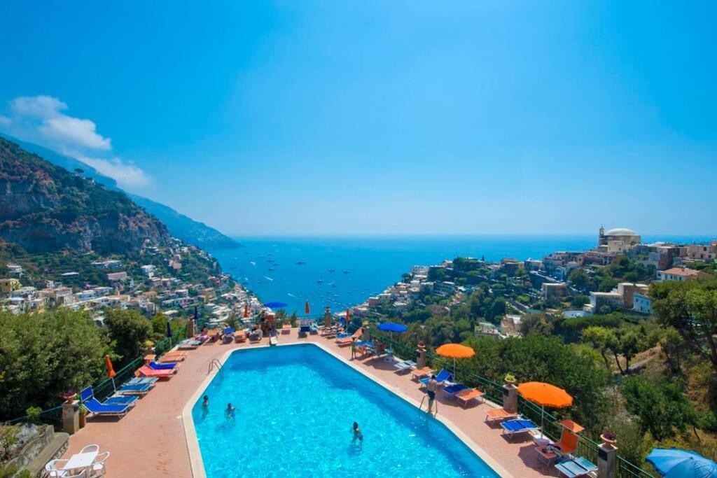 una piscina con sombrillas y el océano en Casa Giostrello, en Positano