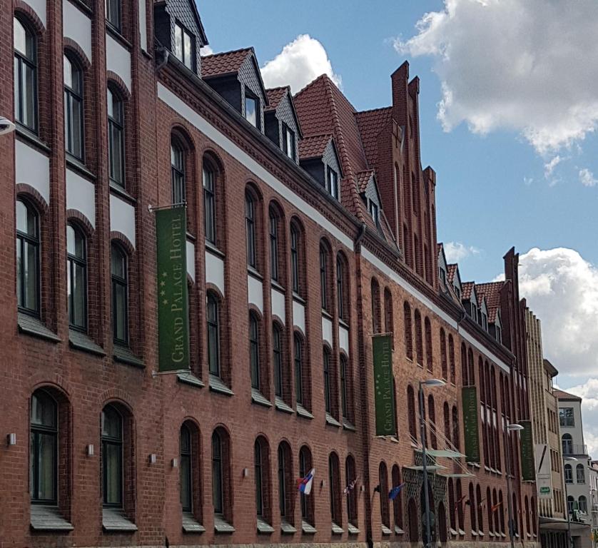 a large brick building with windows on a street at Grand Palace Hotel Hannover in Hannover