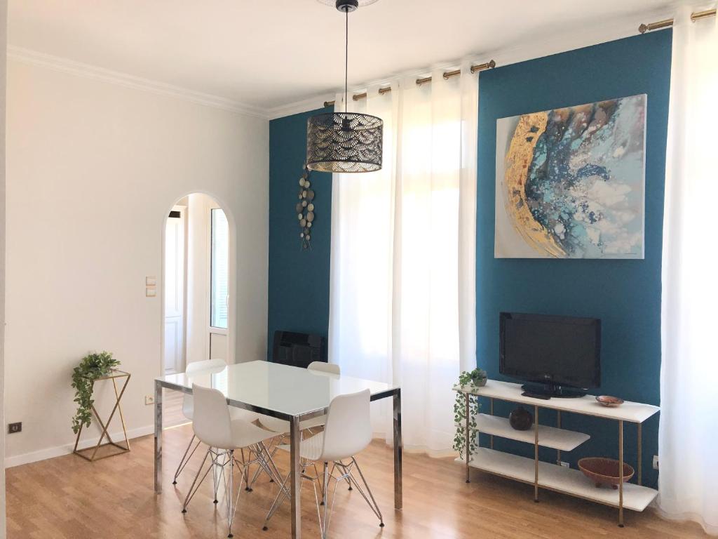 una sala da pranzo con tavolo bianco e TV di Un petit coin de Bastide a Carcassonne