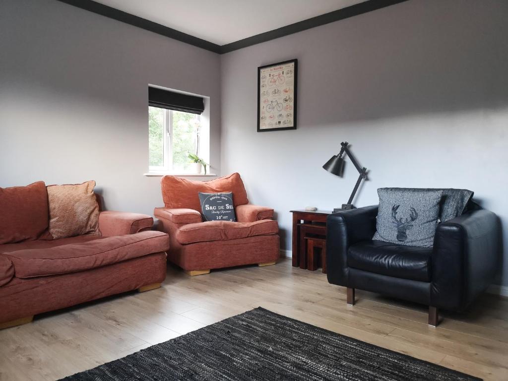 uma sala de estar com um sofá e duas cadeiras em Switchback Stays Marina Apartments em Cardiff