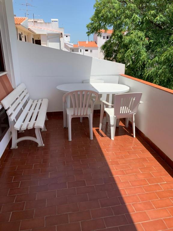 um pátio com 2 cadeiras e uma mesa na varanda em albu centro em Albufeira