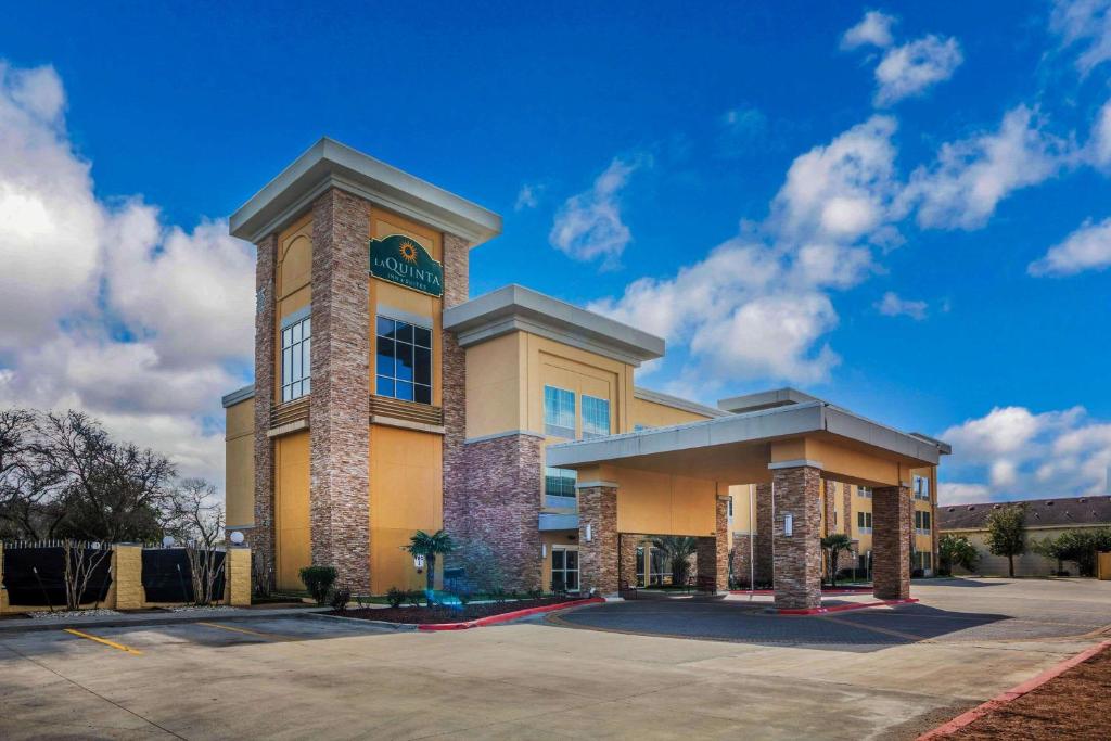 un gran edificio amarillo con un reloj. en La Quinta by Wyndham Beeville, en Beeville