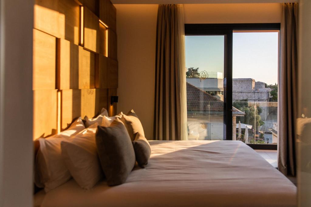 a bedroom with a large bed with a large window at Old Port Hotel in Limassol