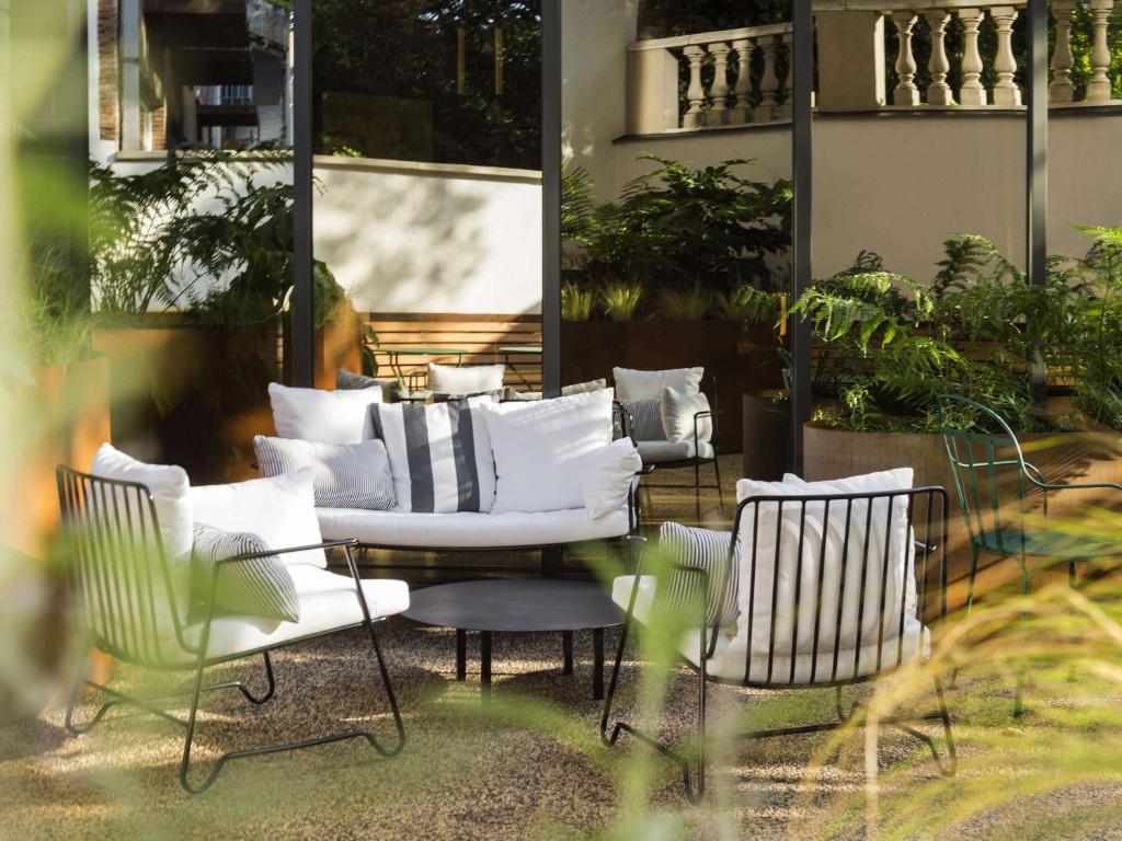 a group of chairs and tables in a patio at ibis Brussels Centre Chatelain in Brussels