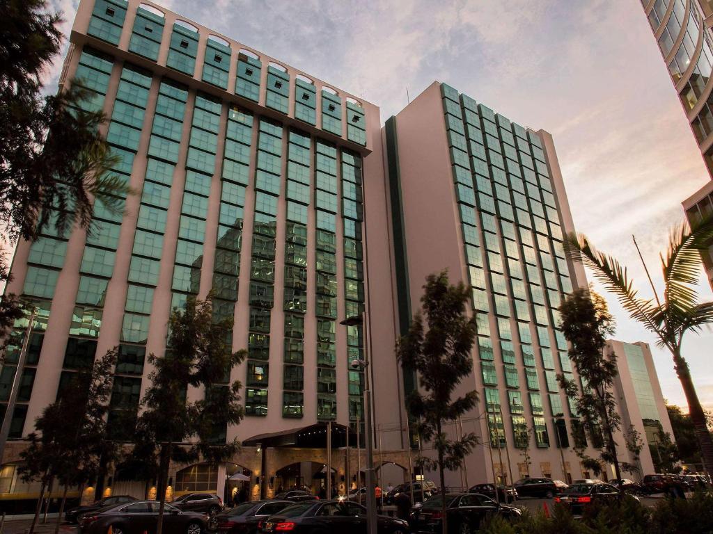 un edificio alto con macchine parcheggiate di fronte di Swissotel Lima a Lima