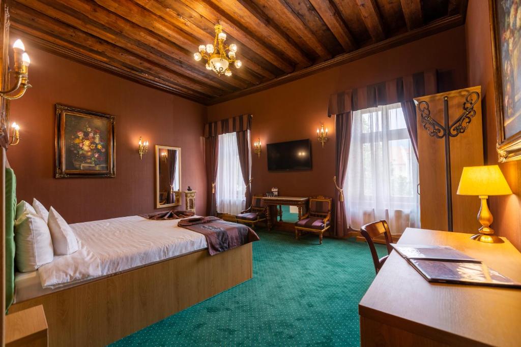 ein Schlafzimmer mit einem Bett und einem Schreibtisch in einem Zimmer in der Unterkunft Hotel Am Ring in Sibiu