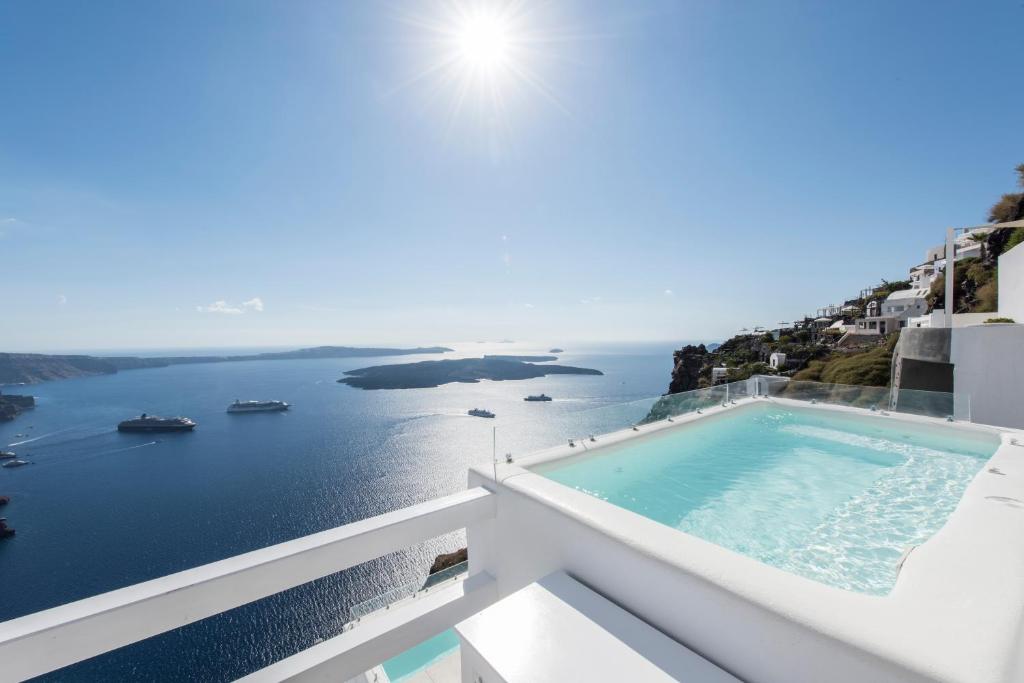 uma vista para o oceano a partir da varanda de uma casa em Aqua Luxury Suites by NOMÉE Hospitality Group em Imerovigli