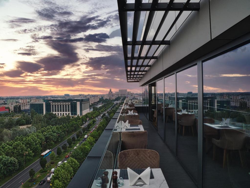 a restaurant with a view of the city at sunset at Union Plaza Hotel in Bucharest