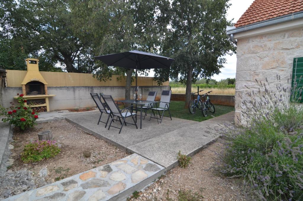 a patio with a table and chairs and an umbrella at Stone House in Kaočine