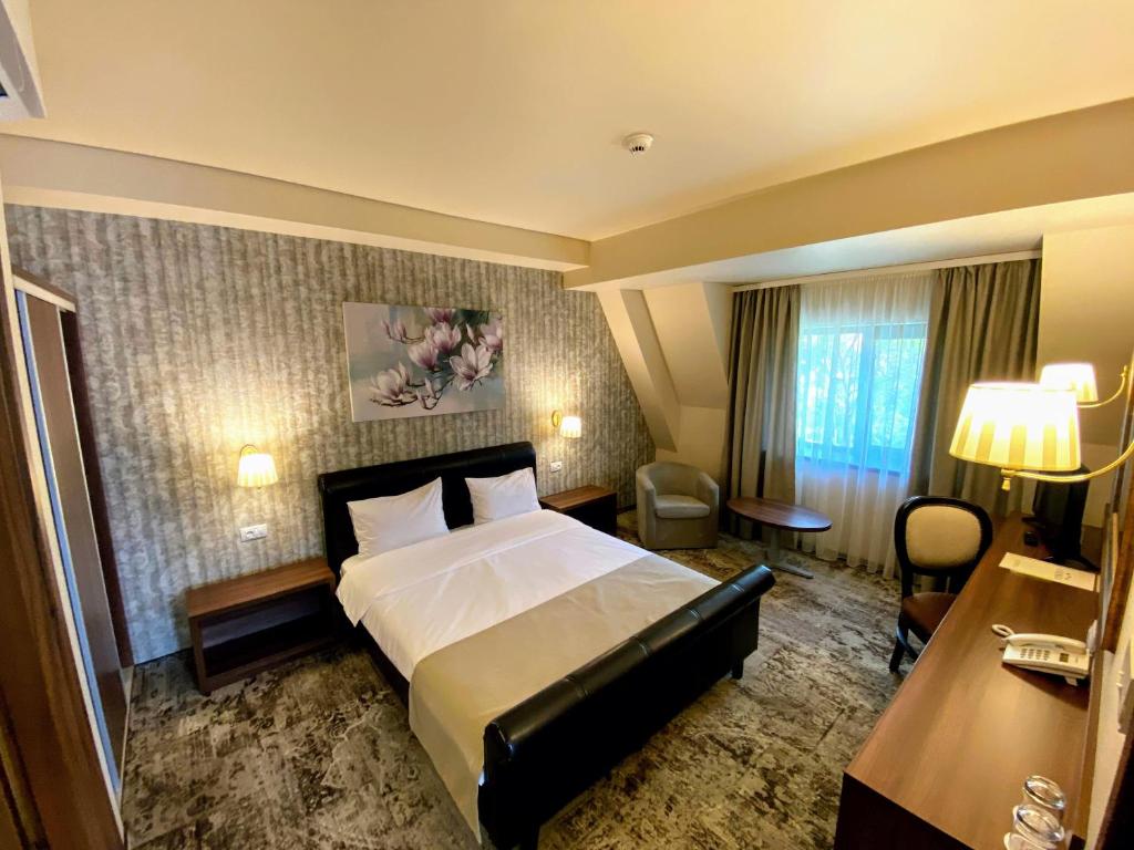 - une chambre d'hôtel avec un grand lit dans l'établissement Hotel Arnia, à Iaşi