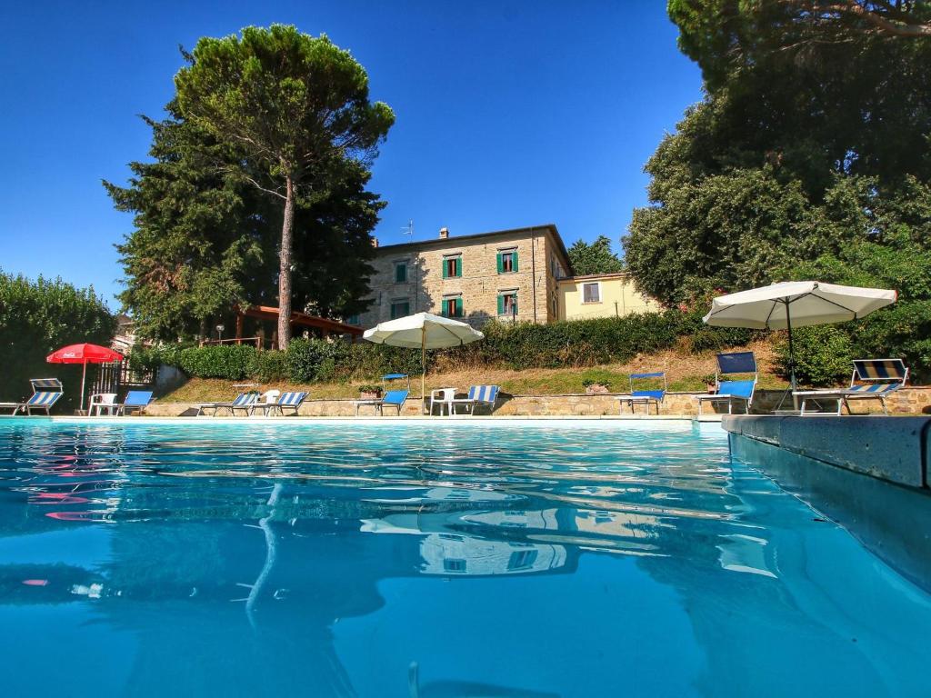 einen Pool mit Stühlen und Sonnenschirmen in der Unterkunft Belvilla by OYO I Molinari in Gualdo Cattaneo
