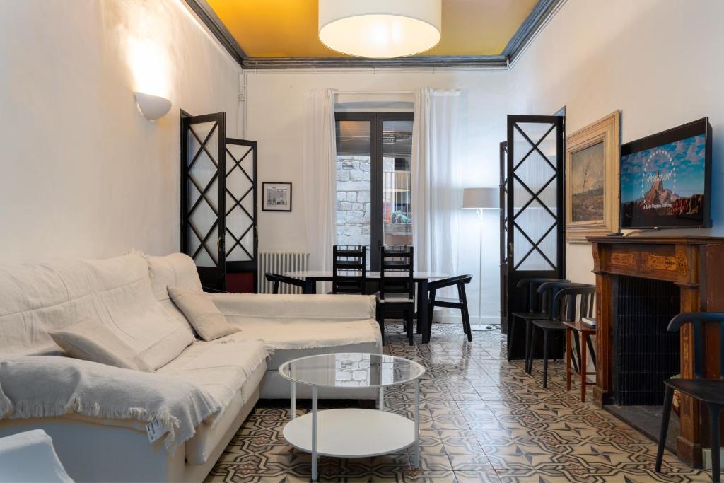 sala de estar con sofá blanco y mesa en Flateli Peixateries Velles, en Girona