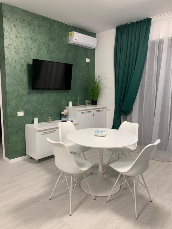 a dining room with a white table and chairs at Apartament Alexandra in Mamaia