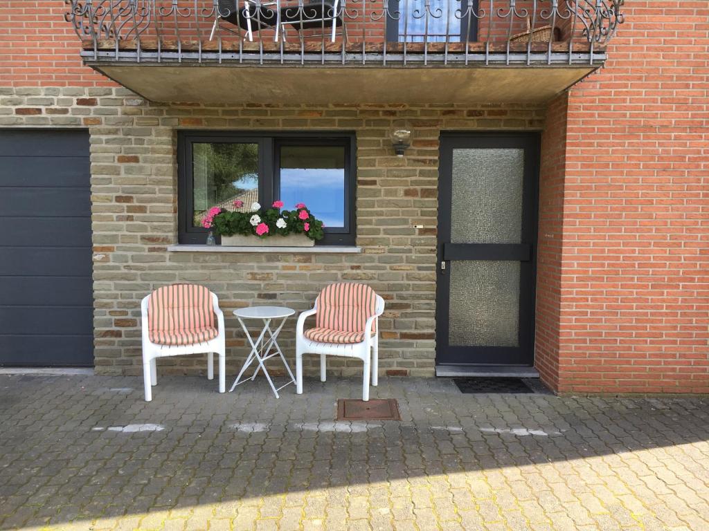 two chairs and a table in front of a building at Chalet M in Eupen
