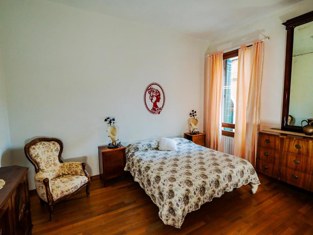 ヴェネツィアにあるLove Island Veniceのベッドルーム1室(ベッド1台、椅子、窓付)
