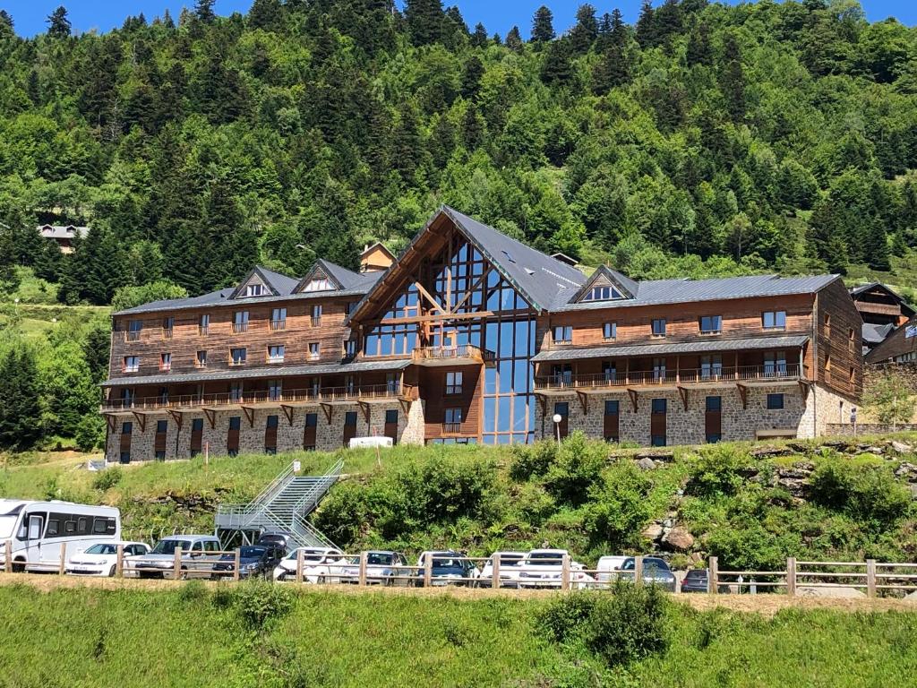 a large building with cars parked in front of it at Appartement 4 personnes aux pieds des pistes, Ariège in Ustou