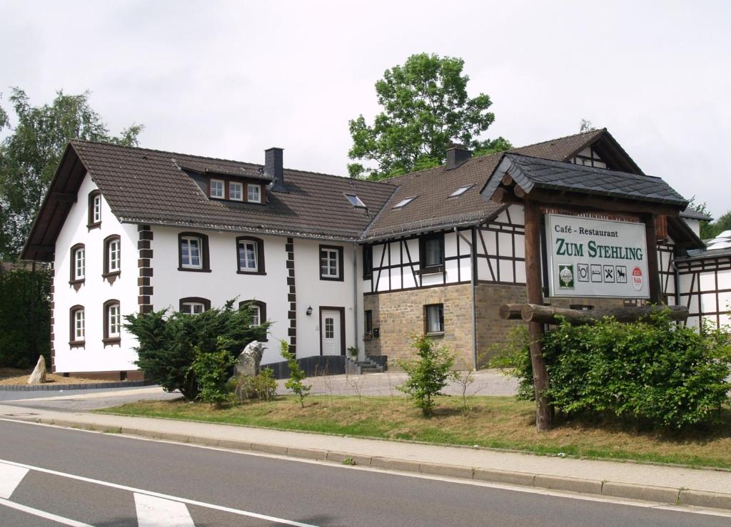 um grande edifício branco com uma placa em frente em Gästehaus Zum Stehling em Monschau