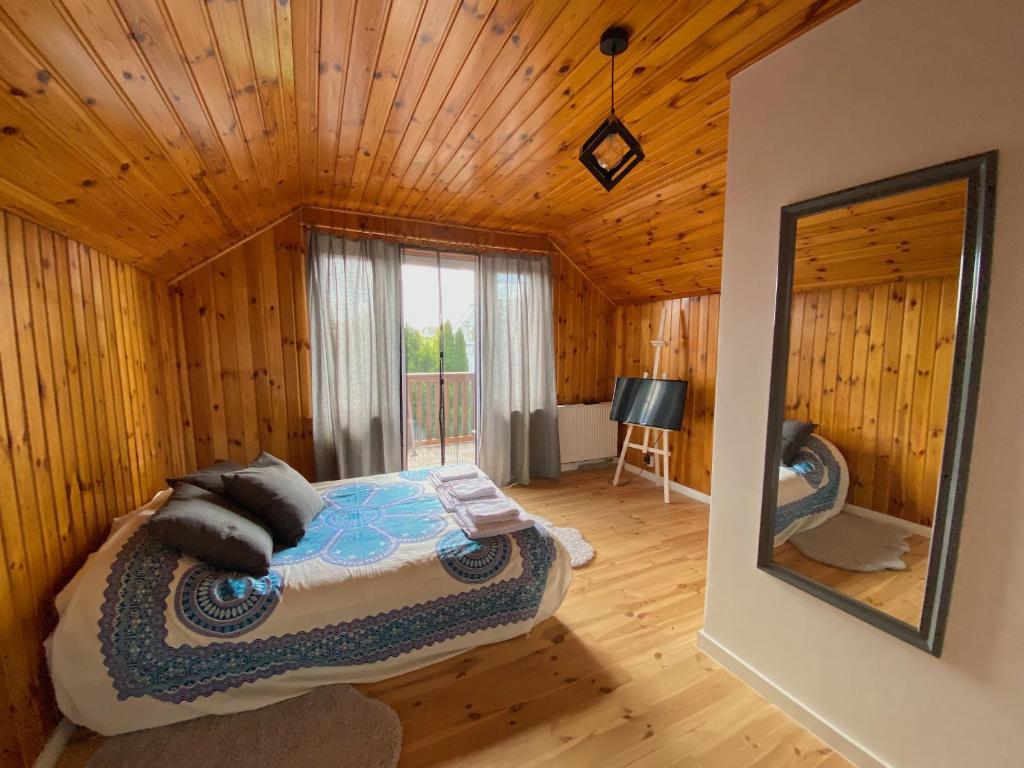 a bedroom with a bed in a wooden cabin at Komoda Tykocin in Tykocin