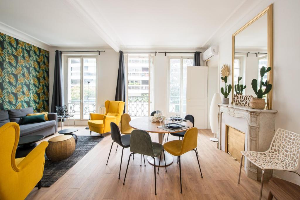 un salon avec une table et des chaises dans l'établissement 2 BR Appartement Near Tour Eiffel & Trocadéro, à Paris