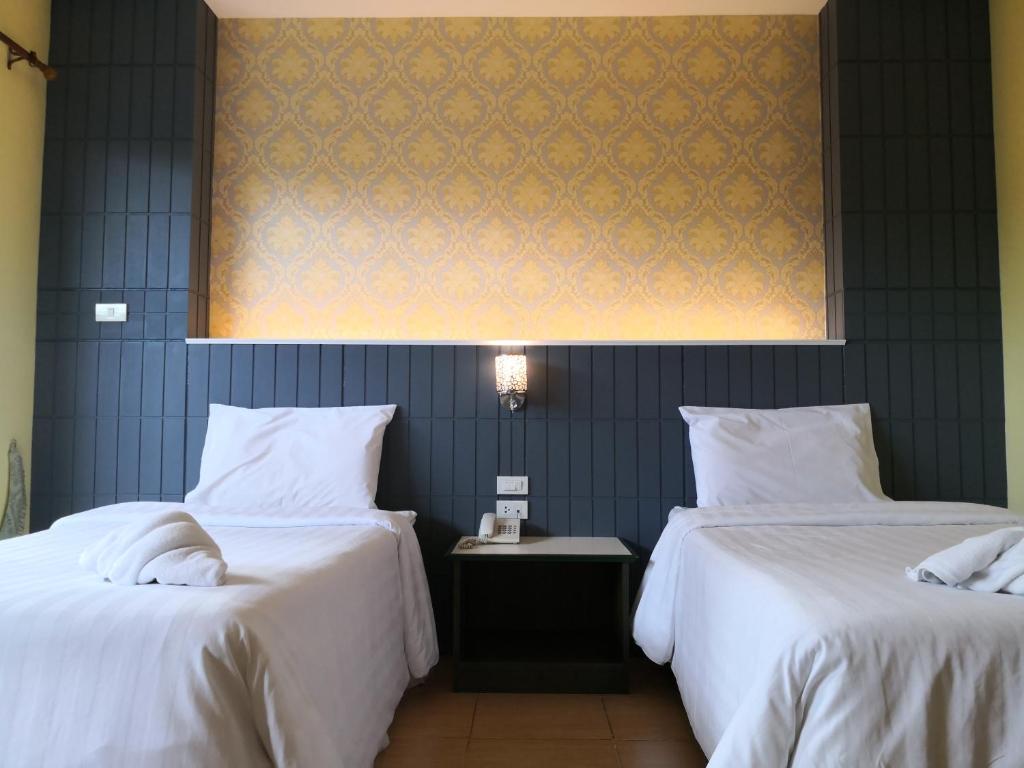 Postel nebo postele na pokoji v ubytování Baan Suksiri Hotel