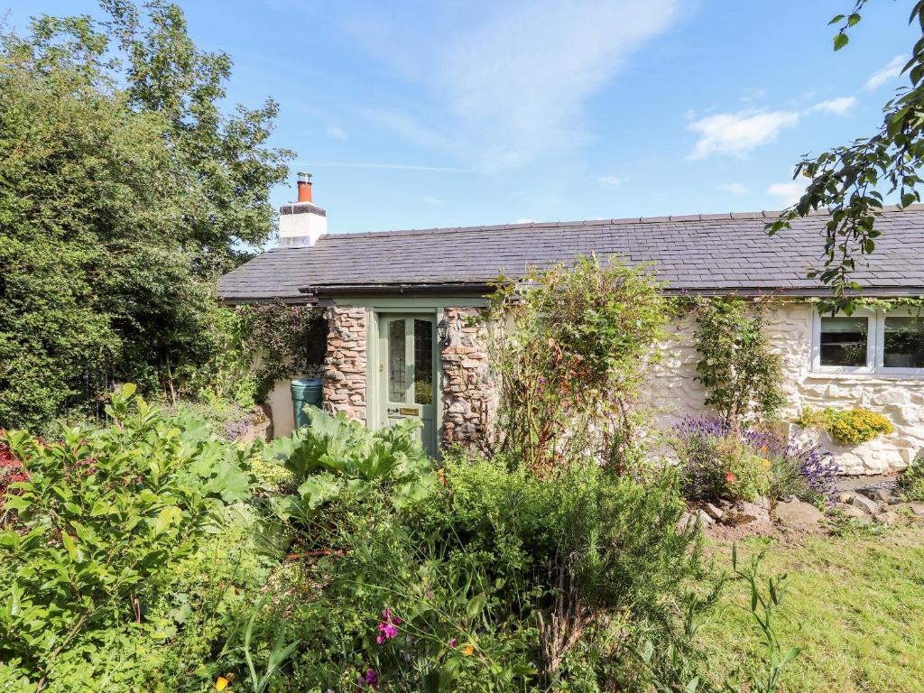 a stone cottage with a garden in front of it at Ysgubor Ucha in Ruthin