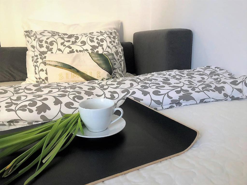 een koffiekopje op een dienblad naast een bed bij Nico Apartments in Krakau