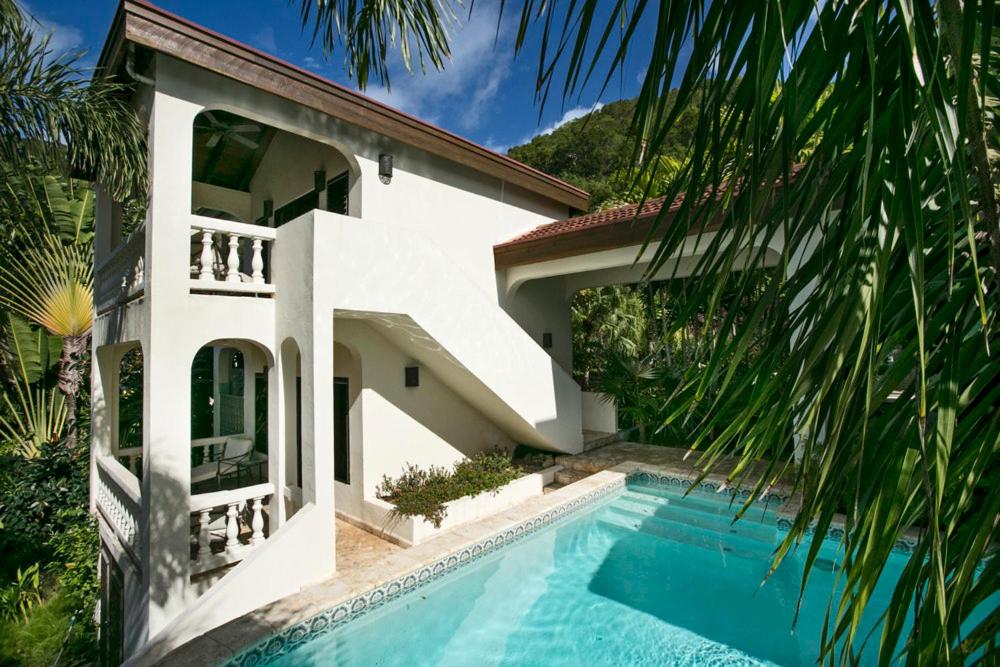 una casa blanca con piscina frente a ella en BELLAMARE en Virgin Gorda