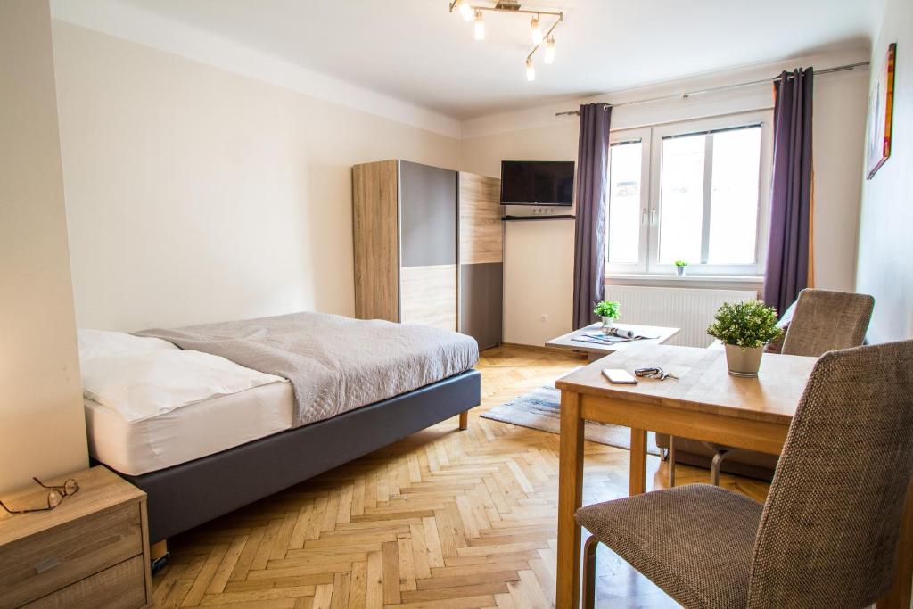 ein Schlafzimmer mit einem Bett und einem Tisch sowie ein Esszimmer in der Unterkunft Apartment Kröllgasse I contactless check-in in Wien