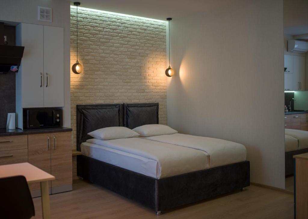 1 dormitorio con cama y pared de ladrillo en Modern apartmeents near Central Park, en Poltava
