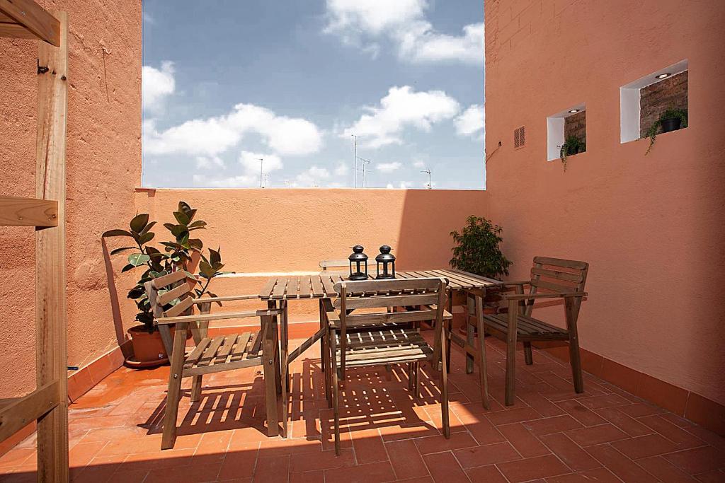 a wooden table and chairs on a balcony with a table and chairs at MUNTANYA - Apartment with balcony Sagrada Familia in Barcelona