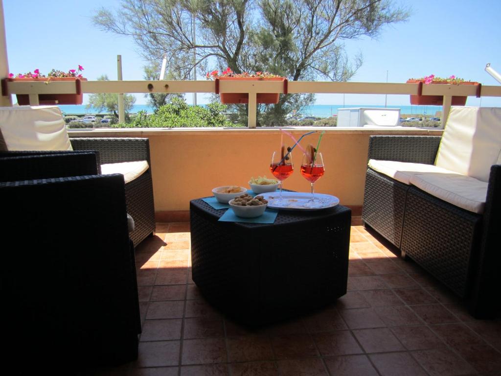 a patio with a table and chairs and a window at Alma Ùnica Fronte Mare in Lido di Ostia