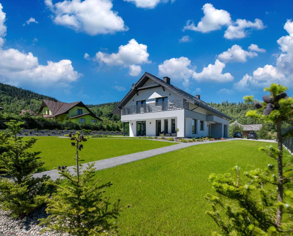 une maison avec une grande cour avec de l'herbe verte dans l'établissement Tramontana, à Stronie Śląskie