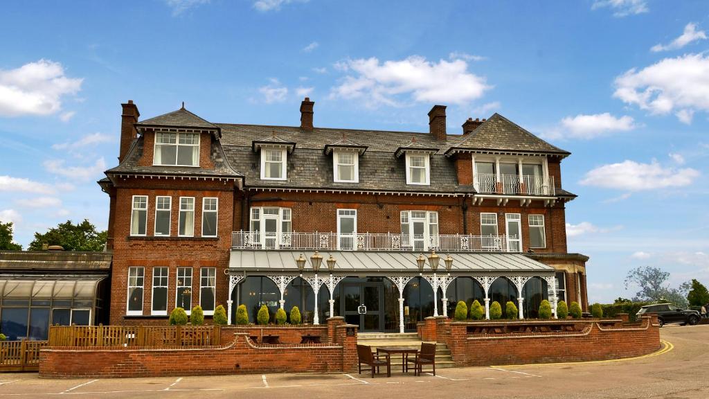 un gran edificio de ladrillo con un balcón en la parte superior. en Wherry Hotel en Lowestoft