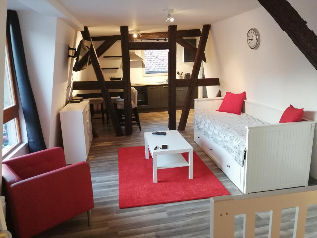 Habitación pequeña con cama y alfombra roja. en Magnifique gîte plein centre de Sélestat en Sélestat