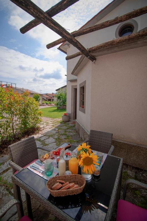 a table with food and flowers on a patio at Tmbin's barn - nature, horses, family in Sežana