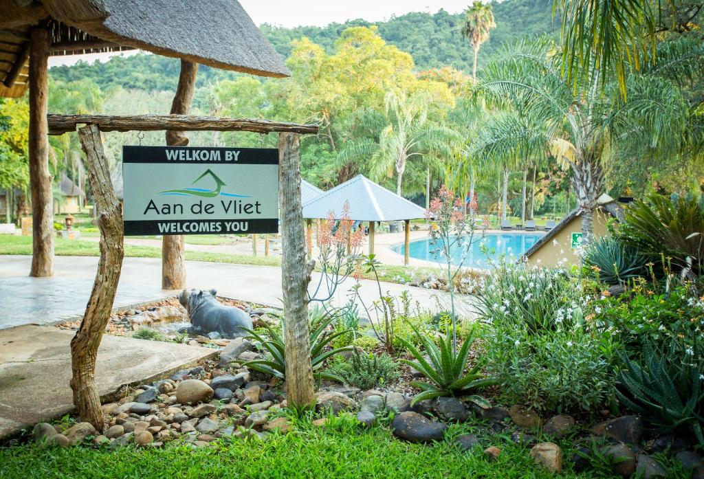 un cartello di fronte alla piscina di un resort di Aan De Vliet Holiday Resort a Hazyview