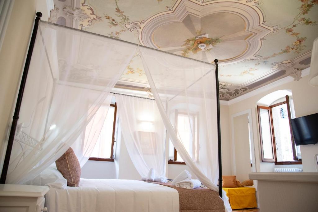 a bedroom with a canopy bed with a ceiling at Dimora Domese in Domodossola