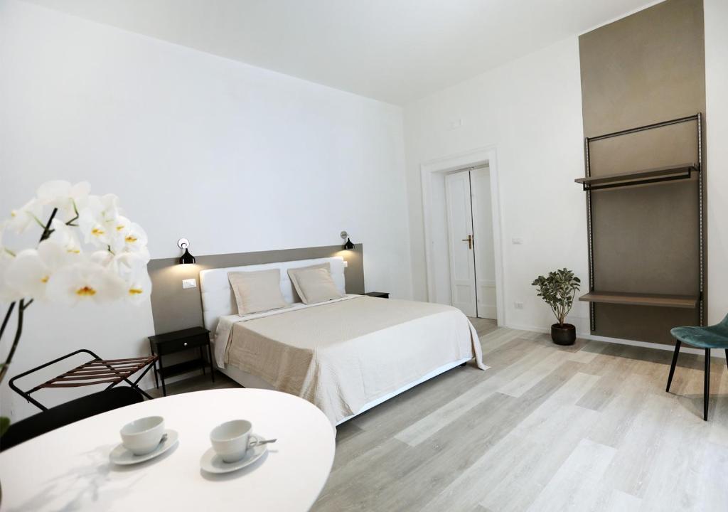 una camera bianca con letto e tavolo di b&b boutique suite bari a Bari