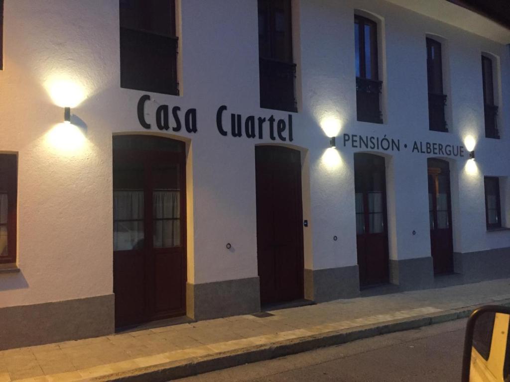 een gebouw met een bord aan de zijkant bij Albergue Casa Cuartel in Fonsagrada