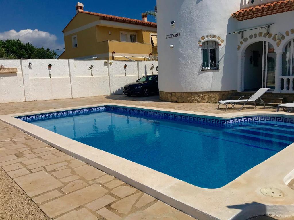 a swimming pool in a yard next to a house at MEDDAYS VILLA NOAH in Miami Platja