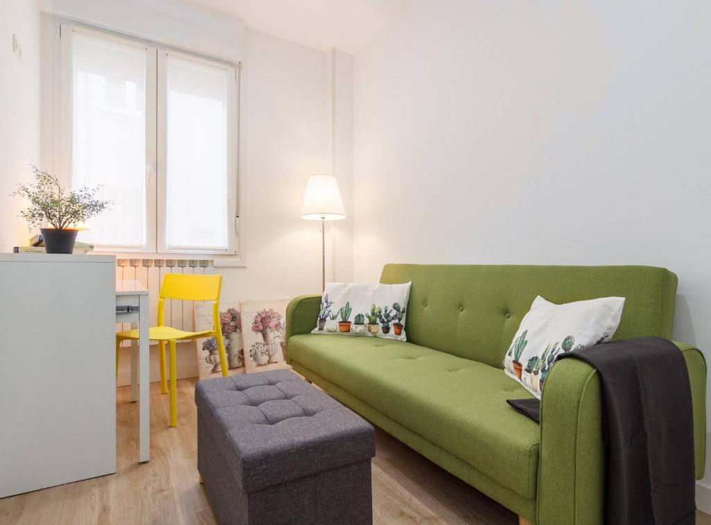 un soggiorno con divano verde e sgabello di Urban Class apartament by the urban hosts a Bilbao