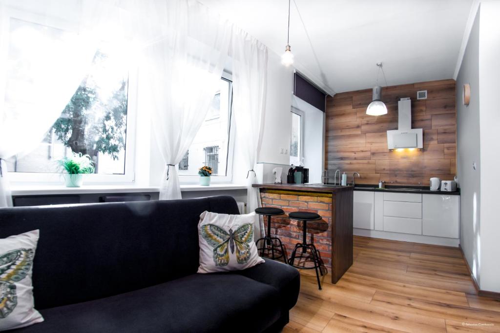 a living room with a couch and a kitchen at Pomeranian House in Gdańsk