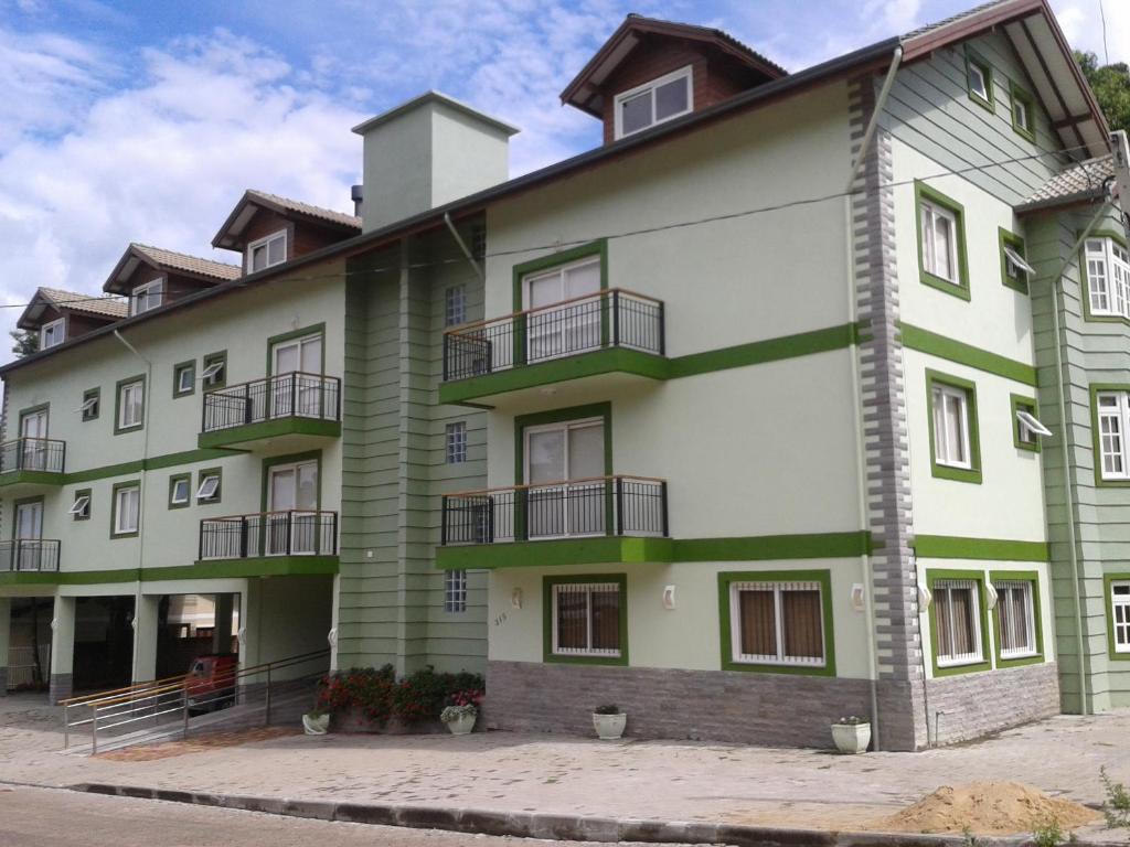 ein großes grünes Gebäude mit Balkonen darauf in der Unterkunft Hotel Carpevita in Canela