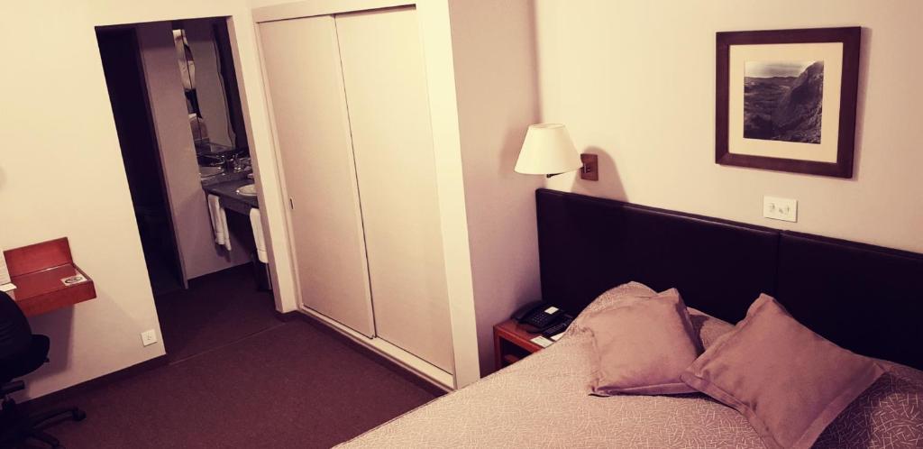 a hotel room with a bed and a bathroom at Comodoro Hotel in Comodoro Rivadavia